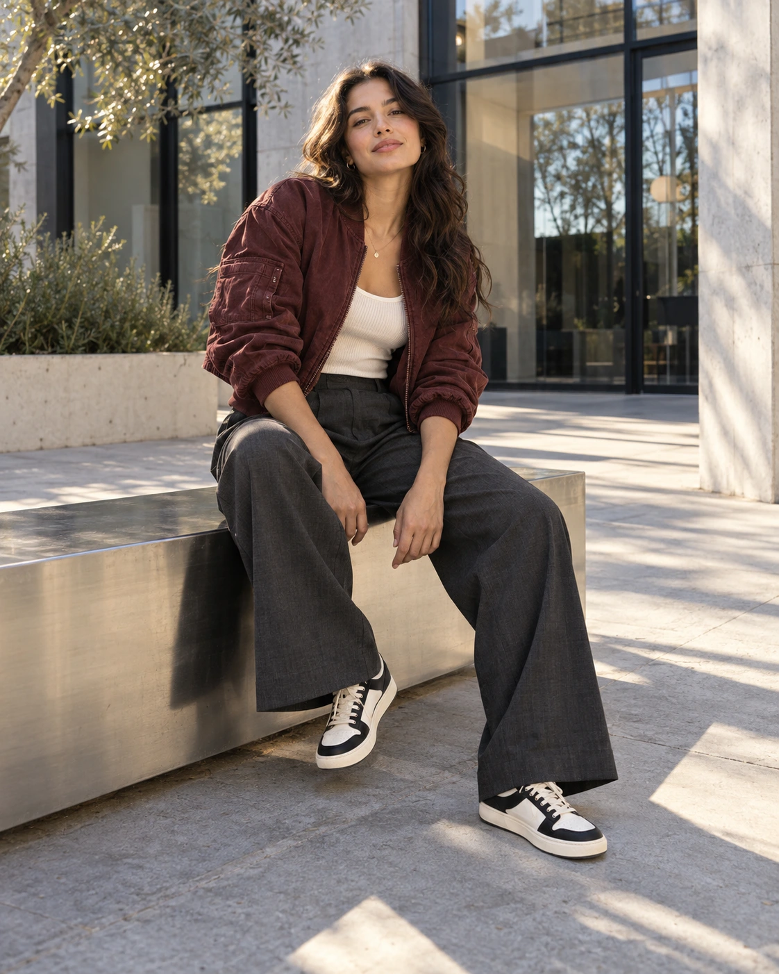 New Foltara styling concept: fictional adult in an open burgundy jacket and wide-leg trousers in a sunlit courtyard